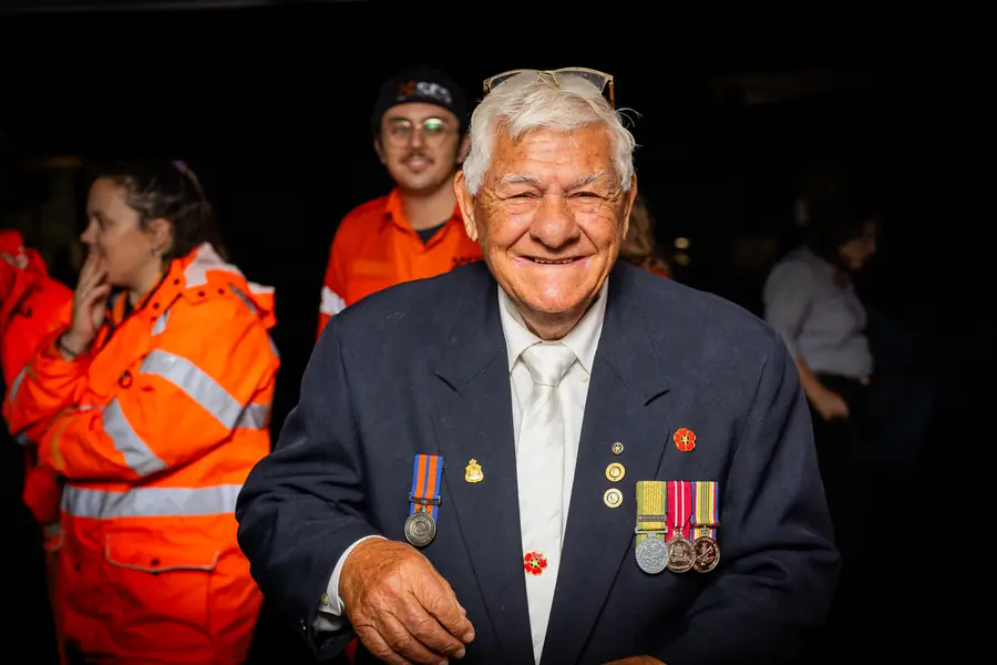A veteran wearing his service medals and a remembrance poppy.