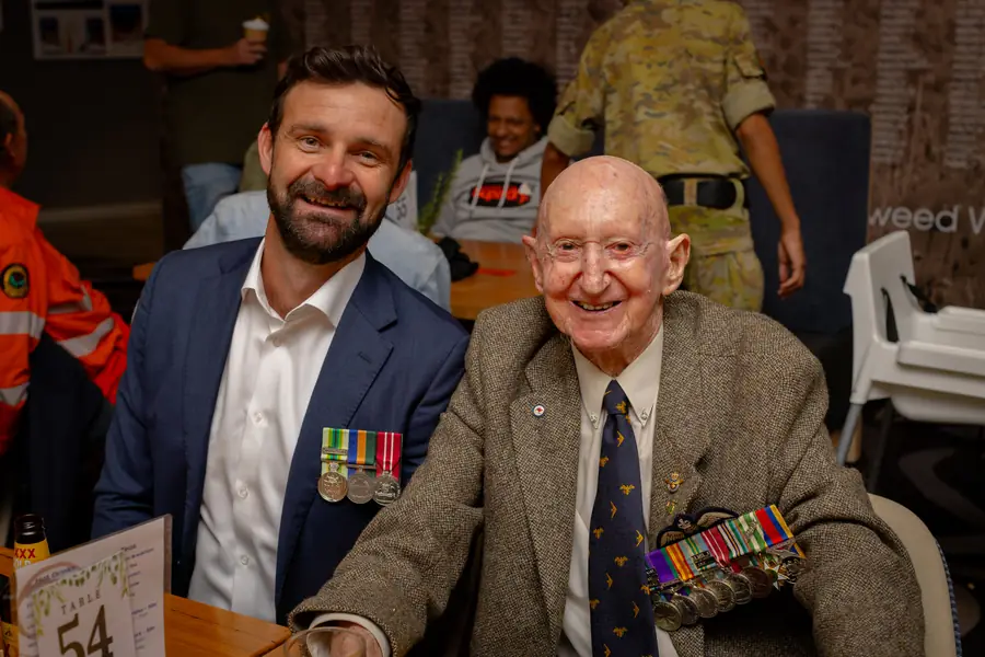 Guests wearing medals gather for ANZAC Day.