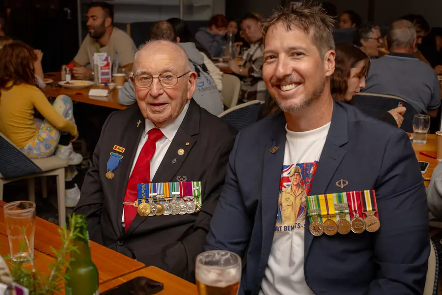 A veteran with his medals joins family for the commemoration.